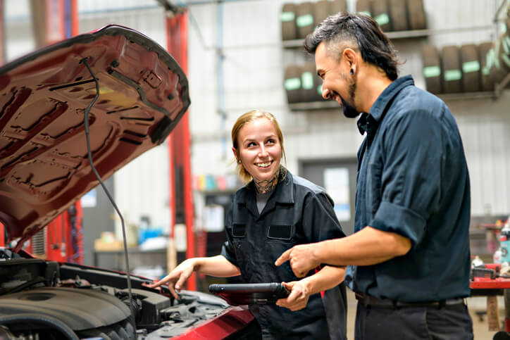 After service advisor training, two colleagues work together to ensure the vehicle is well-serviced.