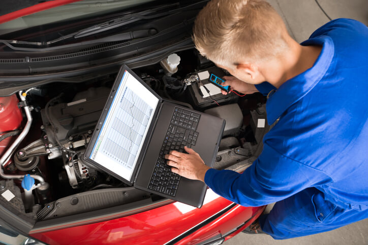 A student in Hybrid and Electrical Mechanic Training tests EVs with tools