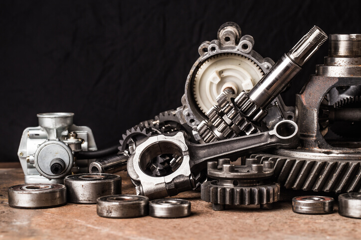 A selection of auto parts on the garage floor in auto parts training when exploring the question are aftermarket parts as good as OEM parts?