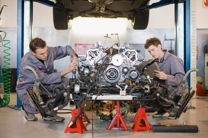 Students in automotive school fixing a car engine