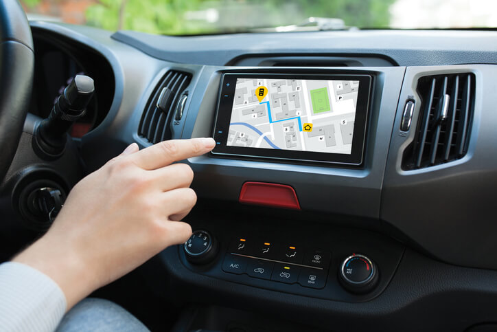 A car driver checking a satellite navigation system for directions after automotive technology training