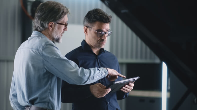 An auto mechanic interacting with his manager after completing auto mechanic school