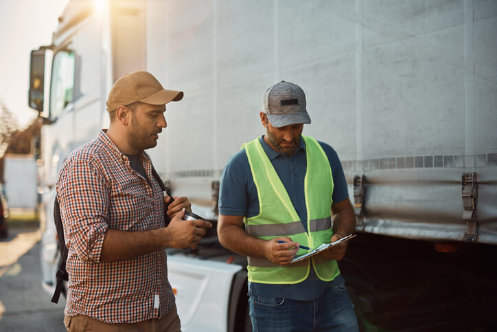 Dispatcher showing a driver some information on a clipboard after completing his dispatch training