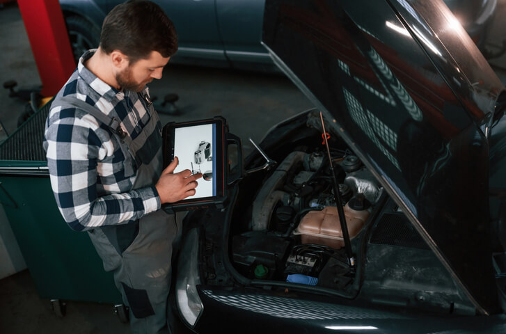 An auto body estimator accessing a vehicle using estimating software after completing automotive training