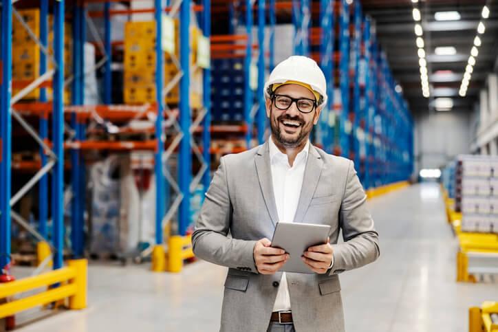 A smiling warehousing clerk taking notes on his tablet after completing her auto parts training