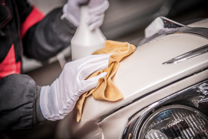 A professional detailer cleaning a vintage car after auto detailing training