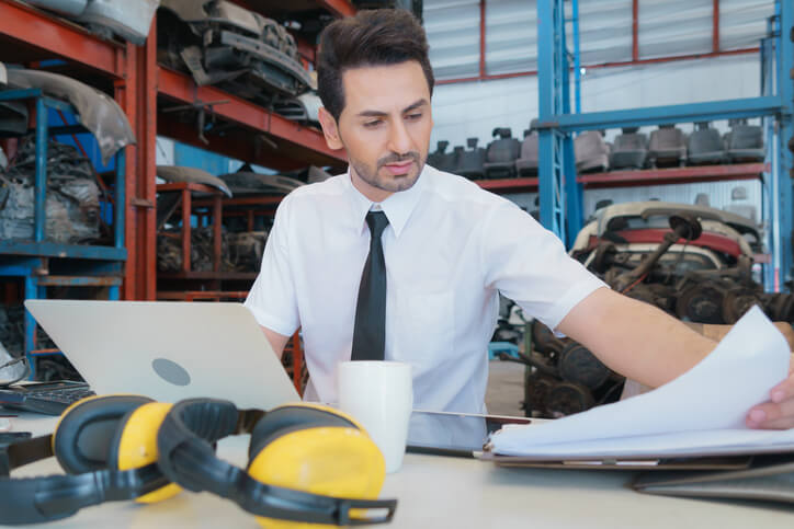 A dedicated male auto parts clerk in an auto shop after completing his auto parts training