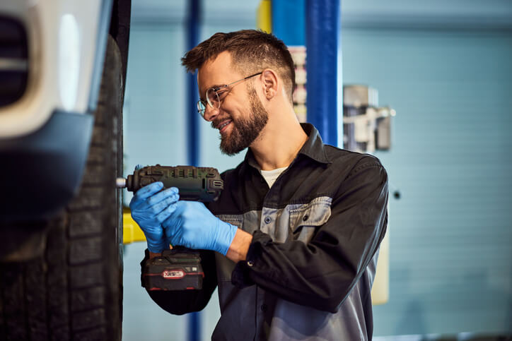 An auto mechanic training grad working on a vehicle in a shop