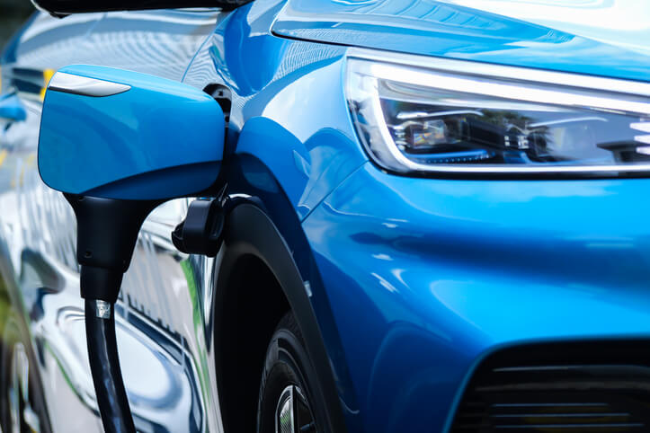 A plug-in hybrid vehicle charging at a street parking lot, to be explored in hybrid and electrical mechanic training