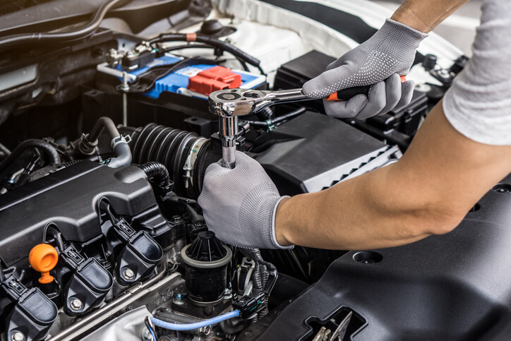 A mechanic tuning the engine of a high-performance vehicle after auto mechanic school