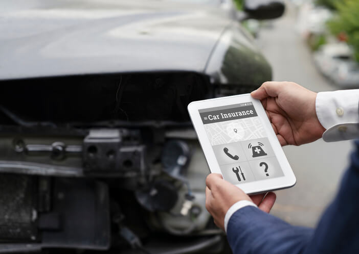 A male collision estimator inspecting a damaged vehicle after completing his auto body training