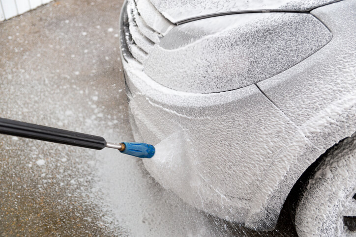 A focused auto detailer dry ice cleaning a car after auto detailing training