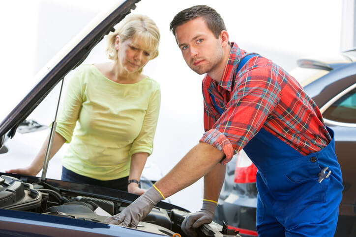 A male mechanic interacting with a female customer after auto mechanic training