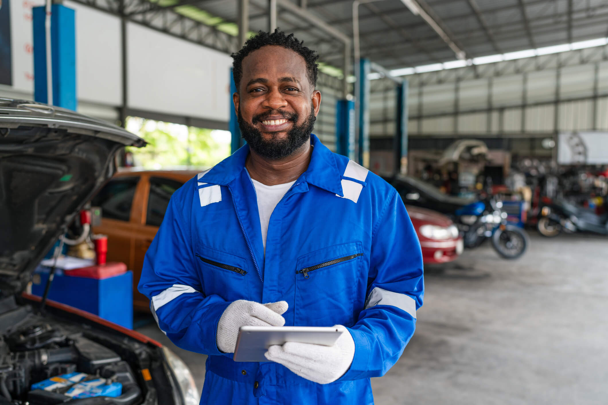 A smiling auto mechanic working in a garage