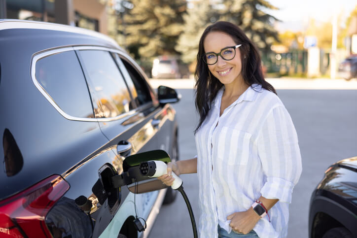 An automotive school grad charging an EV