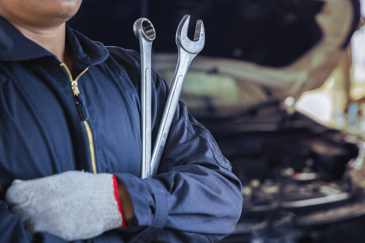 A male hybrid and electric vehicle mechanic at an auto repair shop