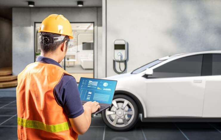 automotive training grad servicing an EV charging station