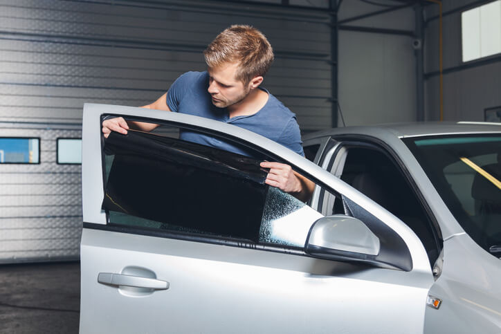 An auto detailing training grad perfecting car window tint