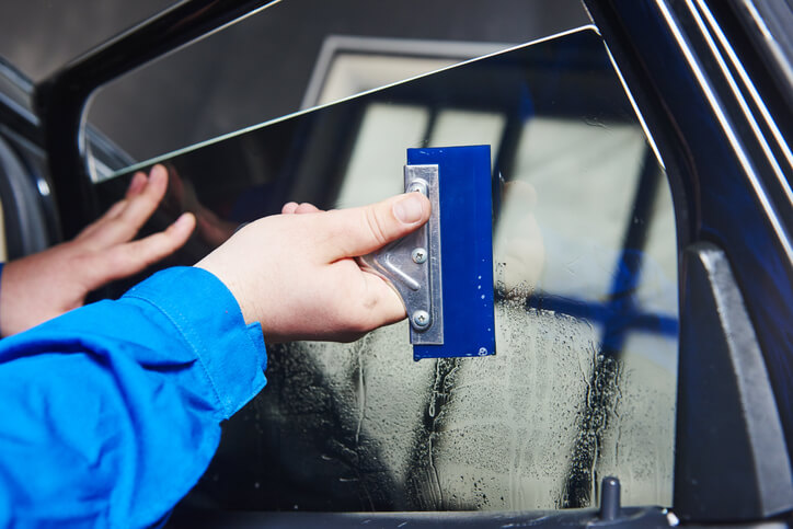 An auto detailing training grad applying tint to a window