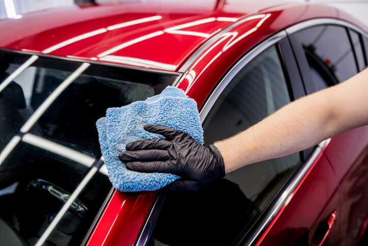 An auto detailing training grad polishing a vehicle