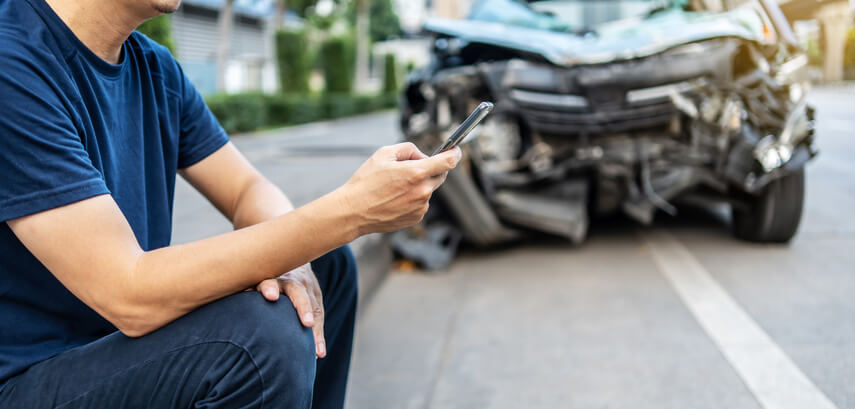 A man calling his insurance agent after an accident after an automotive school class