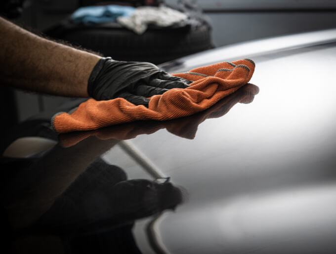 An auto detailing grad applying a protective coating