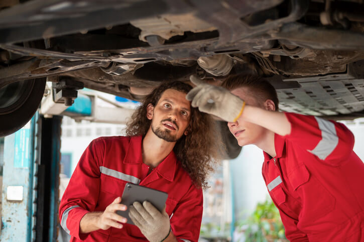 An auto mechanic trainee with an instructor at our automotive school