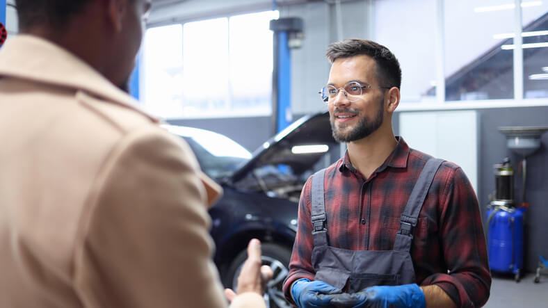 A friendly parts specialist interacting with a customer after completing auto parts training