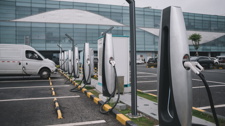 A row of EVs at a charging station, to be explored in automotive training