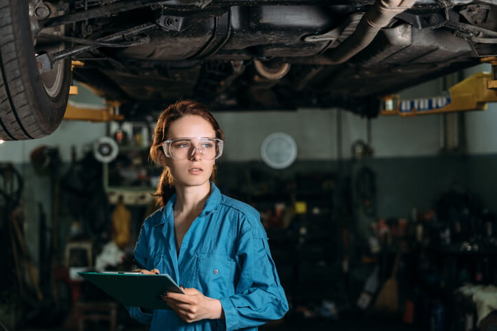 A smiling auto mechanic posing in uniform