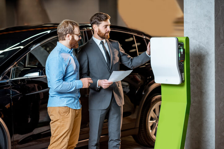 An automotive school graduate inspecting an EV charger