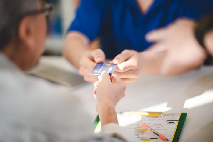 A friendly auto parts clerk processing a customer’s payment after completing his auto parts training