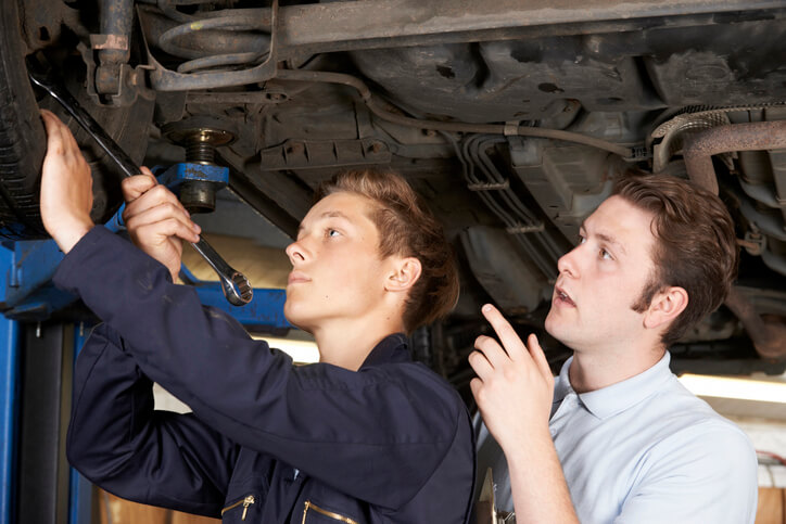 An auto mechanic student working with an instructor