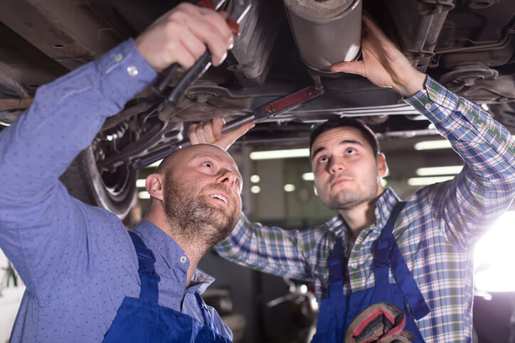 An auto mechanic student working with an instructor