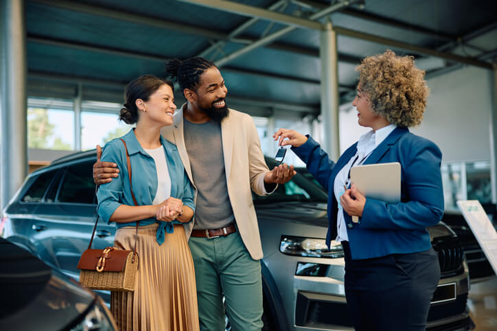 An auto mechanic buying a new vehicle with a spouse at a dealership