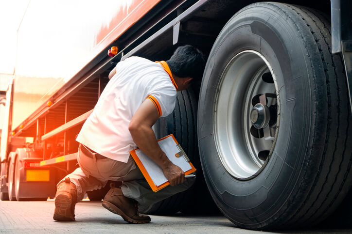 A dispatch training grad conducting a safety check on a truck