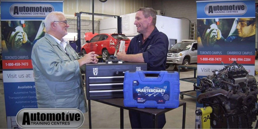 An auto mechanic with trainee, Daniel Endresza