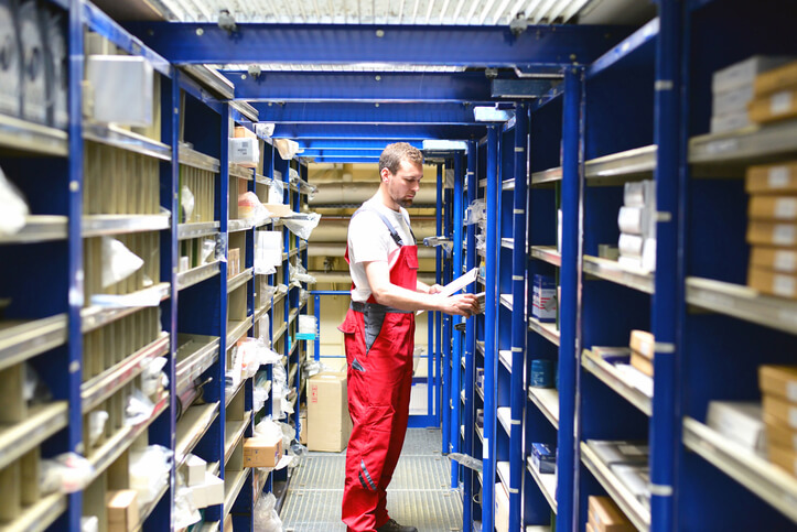 A male parts manager checking inventory at an auto shop after completing his auto parts training