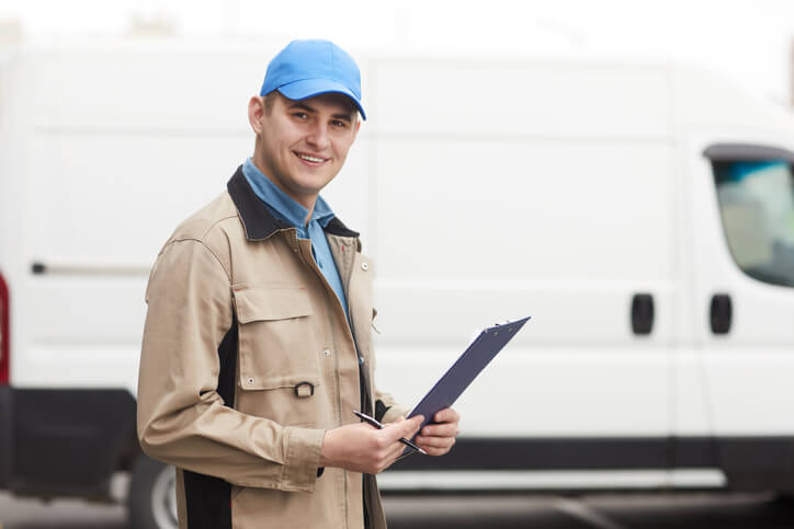 A smiling male dispatcher holding a notepad after completing his dispatch training