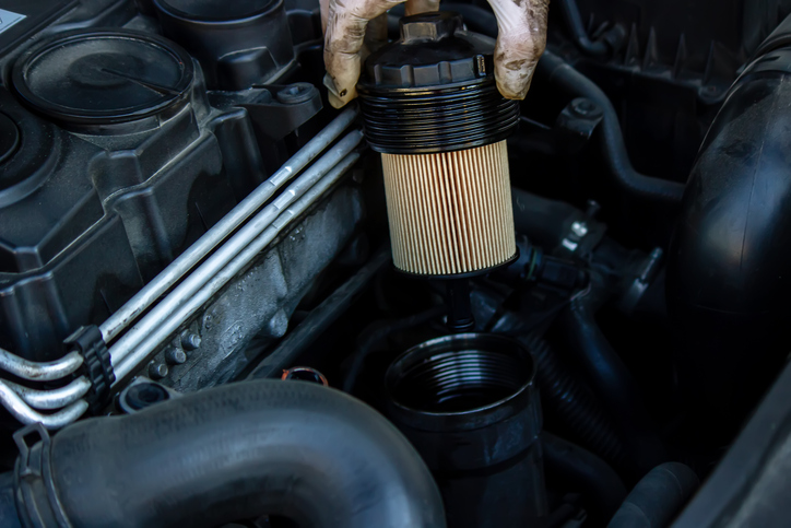 Auto mechanic checking a car’s oil filter after completing his auto mechanic training