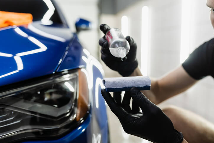 A male auto detailer using an environmentally friendly product after completing his auto detailing training