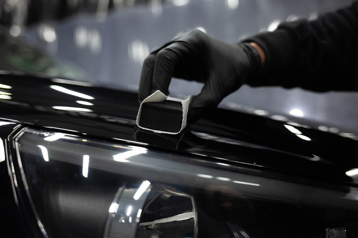 auto detailing grad applying nanoceramics onto a car