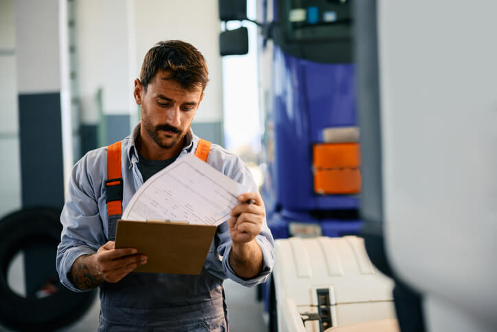 A male auto parts professional documenting changes in a notepad after completing his auto parts training