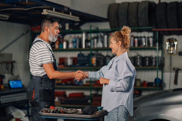 A professional Male auto parts manager interacting with a female customer after completing his auto parts training