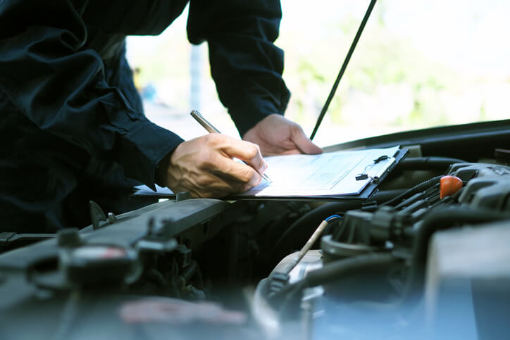 An auto body training grad helping a customer fill out an insurance form