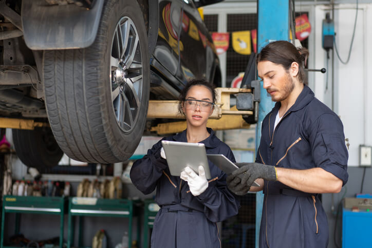 An auto body shop owner advising a technician 