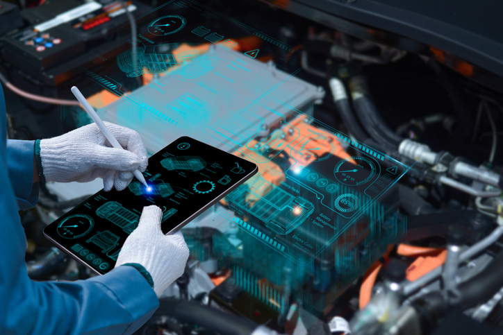 Auto mechanic repairing an electric vehicle after completing his hybrid and electrical mechanic training