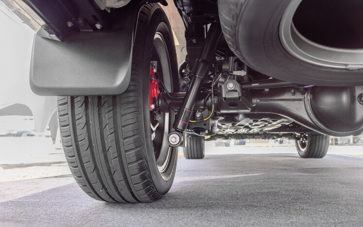 A detailed view of a car's suspension system and tires, showcasing the technical expertise and learning opportunities available at automotive school.