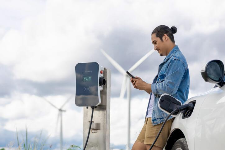 An automotive training grad charging an EV