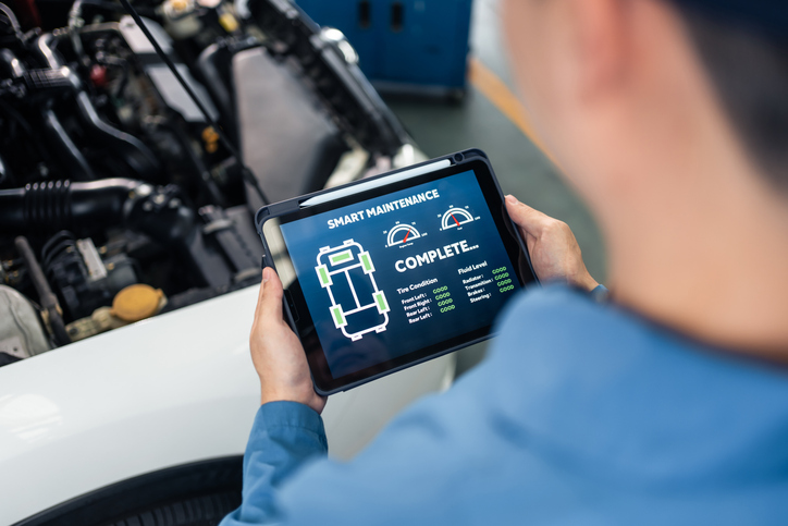 Auto mechanic checking the status of an EV system after completing his hybrid technology training